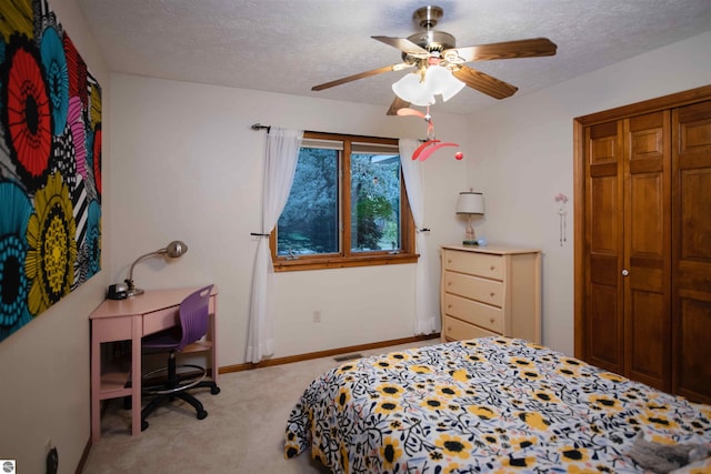10226 Deerpath N, Traverse City, MI 49685 - bedroom with light carpet, a textured ceiling, a desk, ceiling fan, and a closet