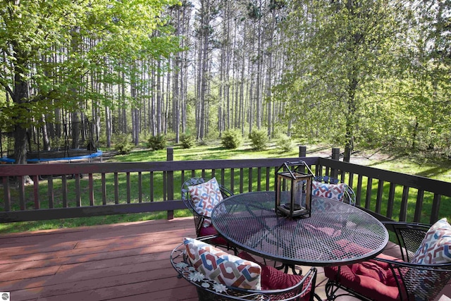 10226 Deerpath N, Traverse City, MI 49685 - deck with a trampoline, outdoor dining area, and a lawn