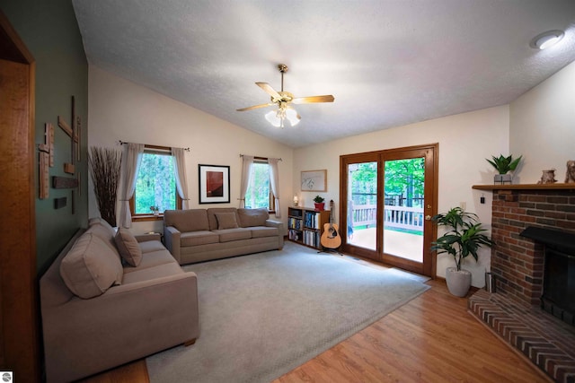10226 Deerpath N, Traverse City, MI 49685 - living room featuring vaulted ceiling, wood finished floors, ceiling fan, and a fireplace