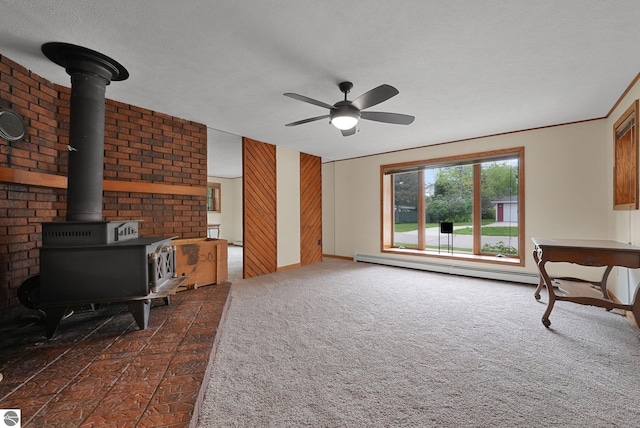 217 Winona Pl, Cadillac, MI 49601 - unfurnished living room with a wood stove, a ceiling fan, a baseboard heating unit, baseboards, and a textured ceiling