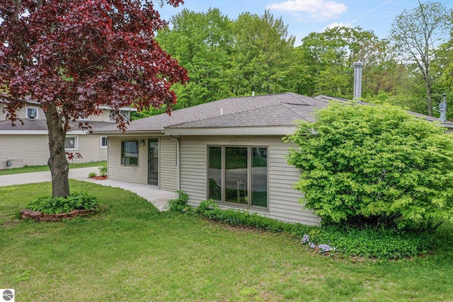 217 Winona Pl, Cadillac, MI 49601 - view of front of house featuring a front yard and a shingled roof