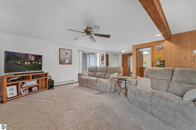 217 Winona Pl, Cadillac, MI 49601 - living room featuring baseboard heating, ceiling fan, beam ceiling, wood walls, and carpet flooring