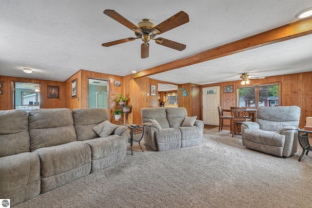 217 Winona Pl, Cadillac, MI 49601 - carpeted living room with a ceiling fan, a textured ceiling, wooden walls, plenty of natural light, and beamed ceiling