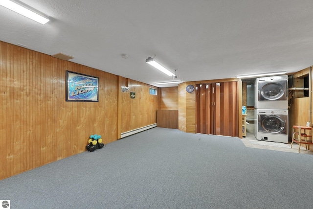 217 Winona Pl, Cadillac, MI 49601 - finished below grade area with stacked washer / drying machine, baseboard heating, carpet, and wood walls