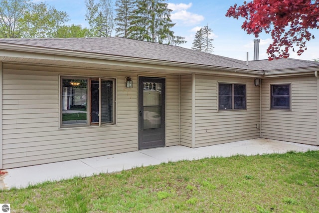 217 Winona Pl, Cadillac, MI 49601 - doorway to property featuring a yard and roof with shingles