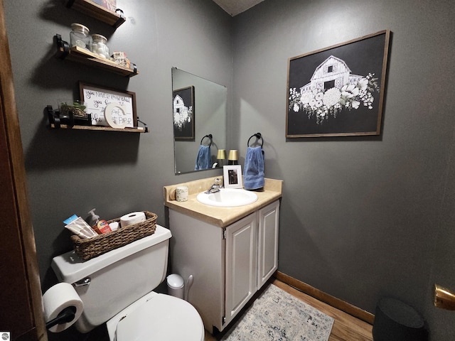 902 S Crapo St, Mount Pleasant, MI 48858 - bathroom featuring toilet, vanity, wood finished floors, and baseboards