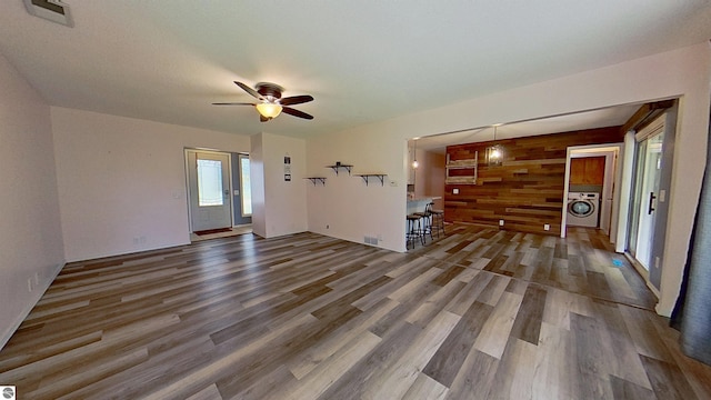 3145 S Concourse Dr, Mount Pleasant, MI 48858 - unfurnished living room with washer / clothes dryer, wood finished floors, and ceiling fan