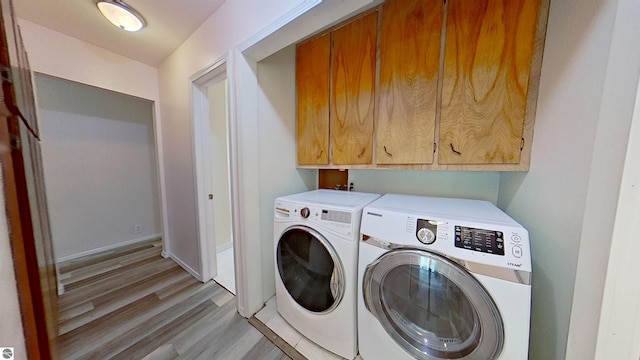 3145 S Concourse Dr, Mount Pleasant, MI 48858 - laundry area with cabinet space, independent washer and dryer, light wood-type flooring, and baseboards