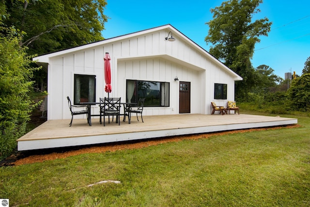 8489 S Glen Lake Rd, Glen Arbor, MI 49636 - rear view of property with a deck, board and batten siding, a yard, and outdoor dining area
