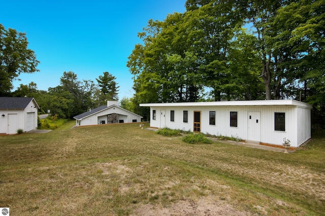 8489 S Glen Lake Rd, Glen Arbor, MI 49636 - back of property with a detached garage, an outdoor structure, and a yard