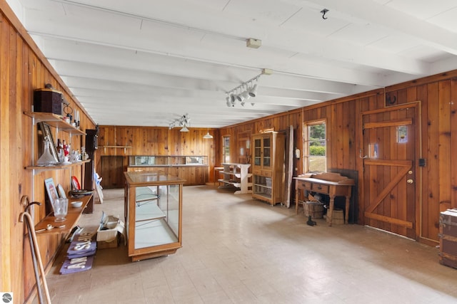 8489 S Glen Lake Rd, Glen Arbor, MI 49636 - miscellaneous room featuring wooden walls, track lighting, beam ceiling, and light flooring