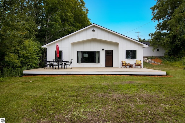 8489 S Glen Lake Rd, Glen Arbor, MI 49636 - rear view of property with a wooden deck, a yard, and board and batten siding