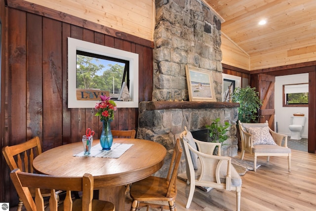 8489 S Glen Lake Rd, Glen Arbor, MI 49636 - dining room with wooden ceiling, wooden walls, lofted ceiling, wood finished floors, and a stone fireplace