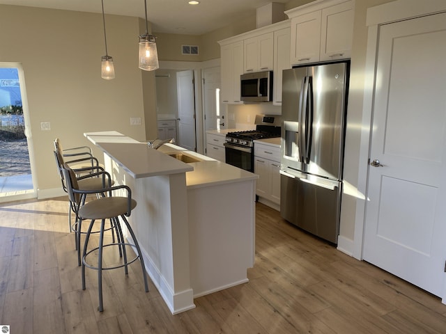 7559 E Meadows Dr Unit 52, Traverse City, MI 49621 - kitchen with stainless steel appliances, a sink, light wood-style flooring, white cabinets, and recessed lighting