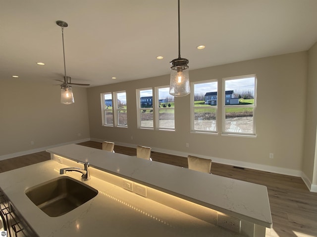 7559 E Meadows Dr Unit 52, Traverse City, MI 49621 - kitchen featuring a sink, wood finished floors, recessed lighting, baseboards, and open floor plan