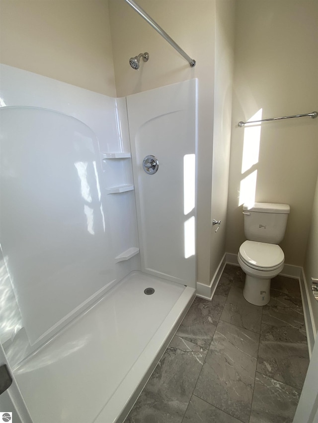 7559 E Meadows Dr Unit 52, Traverse City, MI 49621 - bathroom with marble finish floors, a shower, toilet, and baseboards