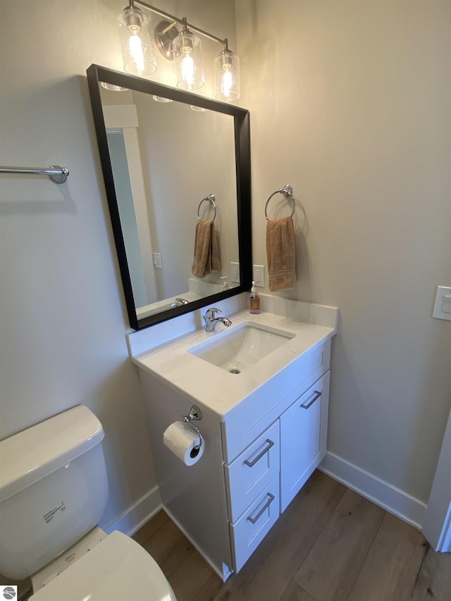 7559 E Meadows Dr Unit 52, Traverse City, MI 49621 - half bath with vanity, wood finished floors, toilet, and baseboards
