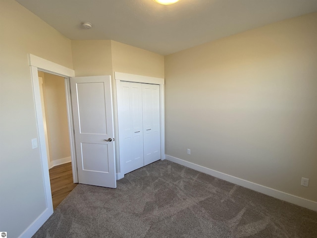 7559 E Meadows Dr Unit 52, Traverse City, MI 49621 - unfurnished bedroom with dark colored carpet, baseboards, and a closet
