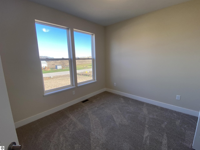 7559 E Meadows Dr Unit 52, Traverse City, MI 49621 - empty room featuring dark carpet and baseboards