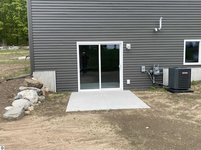 7559 E Meadows Dr Unit 52, Traverse City, MI 49621 - rear view of property with central AC and a patio area