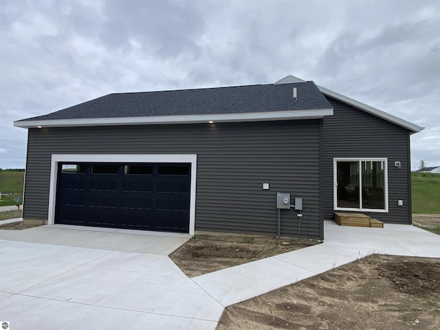 7559 E Meadows Dr Unit 52, Traverse City, MI 49621 - view of side of property featuring driveway, roof with shingles, entry steps, and a garage