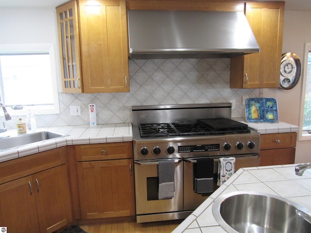 2011 Douglas Dr, Tawas City, MI 48763 - kitchen featuring double oven range, under cabinet range hood, a sink, and backsplash