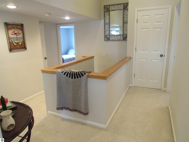 2011 Douglas Dr, Tawas City, MI 48763 - hall with light colored carpet, baseboards, recessed lighting, and an upstairs landing