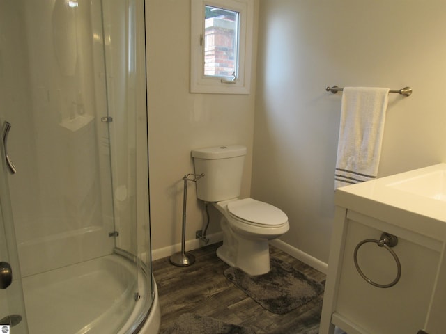 2011 Douglas Dr, Tawas City, MI 48763 - full bath with a shower stall, wood finished floors, baseboards, toilet, and vanity