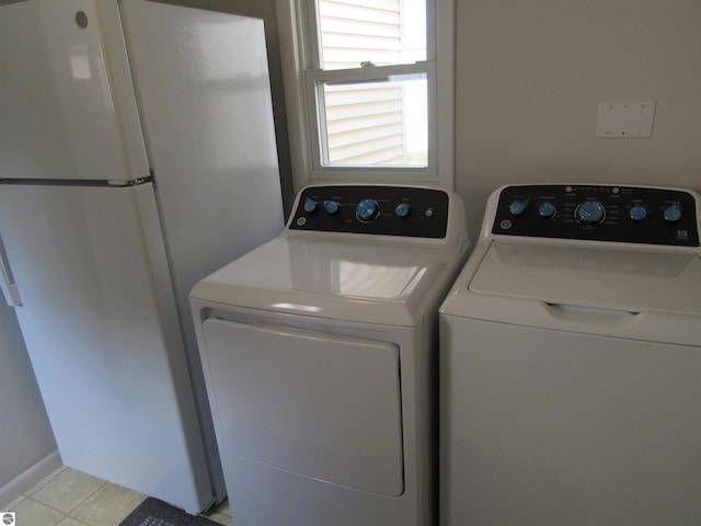 2011 Douglas Dr, Tawas City, MI 48763 - laundry room featuring light tile patterned floors and washing machine and clothes dryer