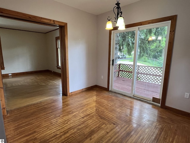 506 E Division St, Cadillac, MI 49601 - unfurnished room featuring baseboards and a chandelier