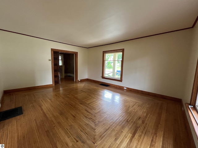 506 E Division St, Cadillac, MI 49601 - empty room featuring baseboards, crown molding, and wood finished floors