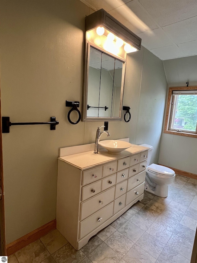 506 E Division St, Cadillac, MI 49601 - bathroom with vanity, toilet, baseboards, and lofted ceiling