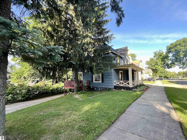 506 E Division St, Cadillac, MI 49601 - view of side of property with covered porch and a lawn