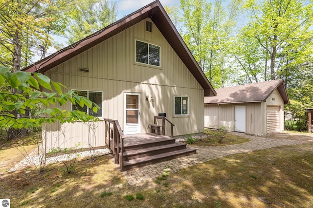 3228 S Skeba Rd S, Lake Leelanau, MI 49653 - rear view of house with an outbuilding, a garage, and board and batten siding