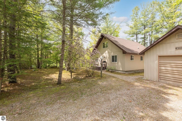 3228 S Skeba Rd S, Lake Leelanau, MI 49653 - view of home's exterior with roof with shingles, a garage, and driveway
