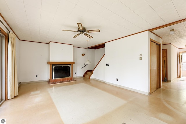 3228 S Skeba Rd S, Lake Leelanau, MI 49653 - unfurnished living room featuring ceiling fan, stairway, a glass covered fireplace, ornamental molding, and baseboards