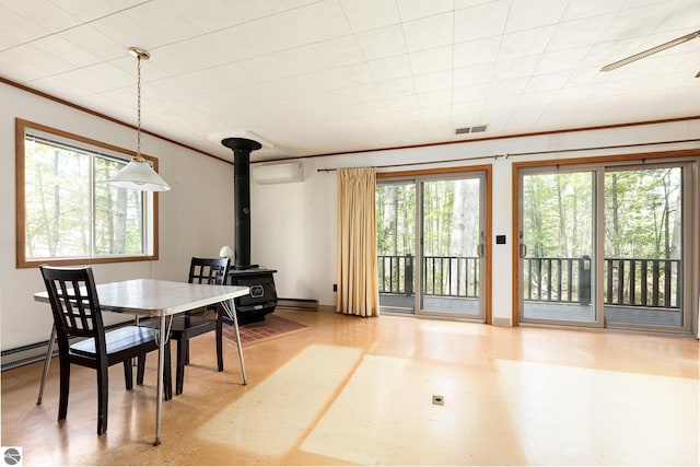 3228 S Skeba Rd S, Lake Leelanau, MI 49653 - dining space with a wood stove, a baseboard heating unit, baseboard heating, crown molding, and a wall unit AC