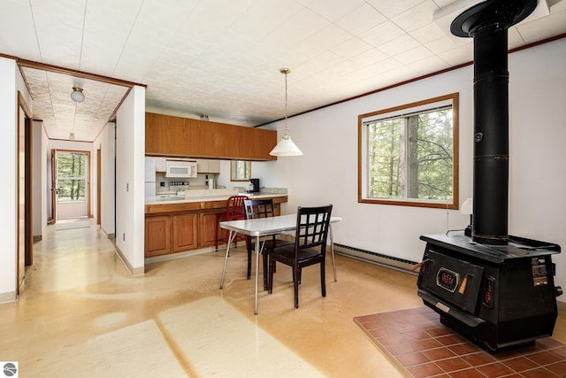 3228 S Skeba Rd S, Lake Leelanau, MI 49653 - dining area featuring baseboard heating, a wood stove, concrete flooring, and baseboards