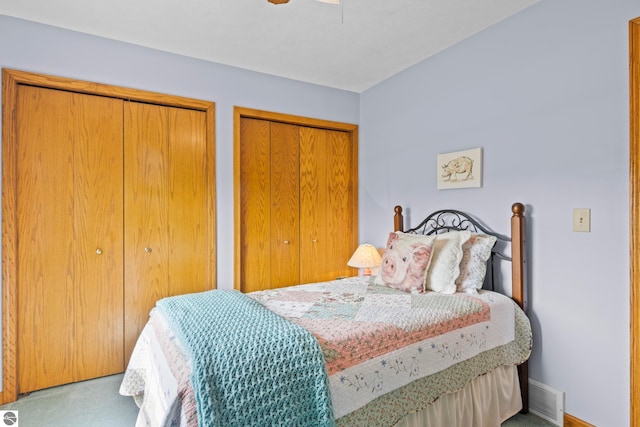 11103 S Ramblewood Dr, Cedar, MI 49621 - carpeted bedroom with two closets, a ceiling fan, and baseboards