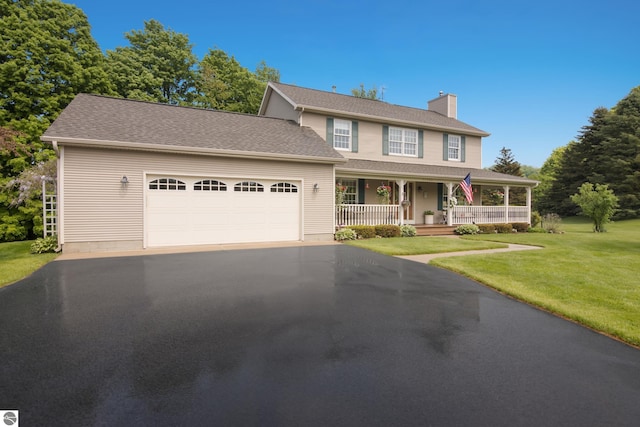 11103 S Ramblewood Dr, Cedar, MI 49621 - view of front of home featuring covered porch, a chimney, asphalt driveway, and a front yard