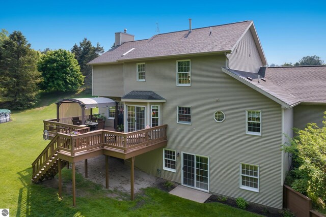 11103 S Ramblewood Dr, Cedar, MI 49621 - rear view of house with a wooden deck, a yard, a shingled roof, a gazebo, and a chimney