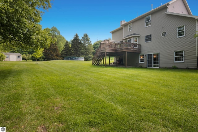 11103 S Ramblewood Dr, Cedar, MI 49621 - rear view of house with a wooden deck, a chimney, stairs, and a lawn