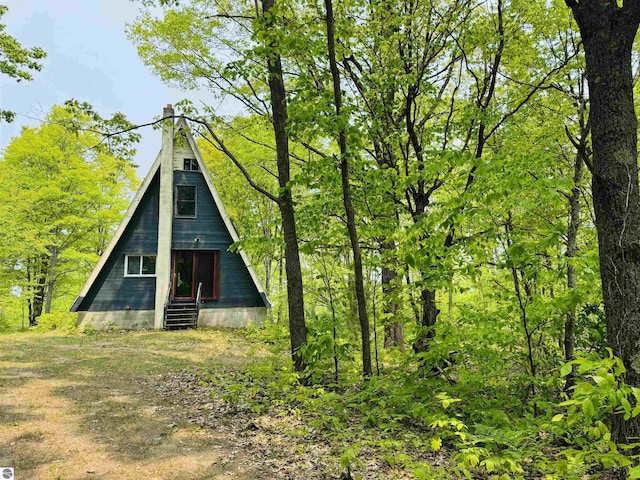 11711 E 22 3/4 Rd, Manton, MI 49663 - back of house with a chimney and entry steps