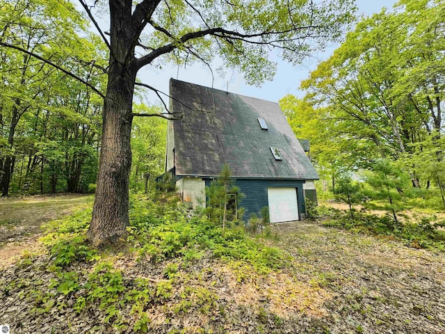 11711 E 22 3/4 Rd, Manton, MI 49663 - view of home's exterior with a garage and a shingled roof