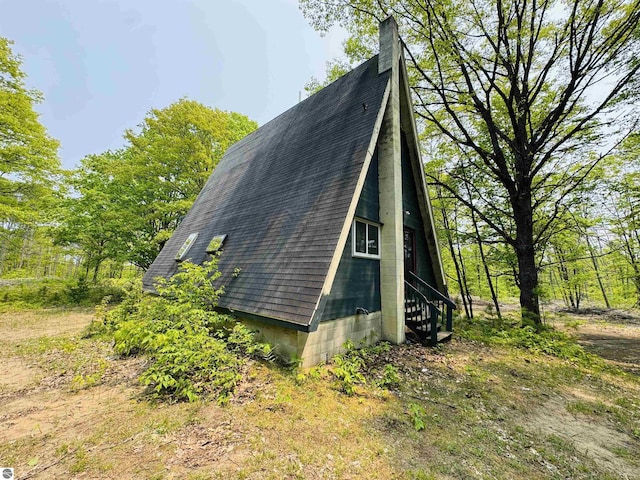 11711 E 22 3/4 Rd, Manton, MI 49663 - view of side of home with roof with shingles and a chimney
