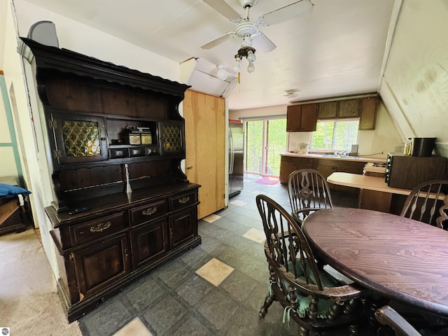 11711 E 22 3/4 Rd, Manton, MI 49663 - dining area featuring a ceiling fan, dark flooring, and vaulted ceiling
