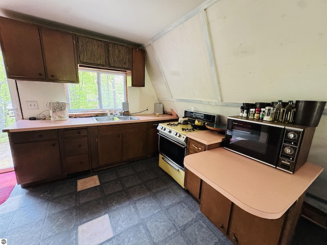 11711 E 22 3/4 Rd, Manton, MI 49663 - kitchen with white range with gas stovetop, black microwave, light countertops, dark brown cabinetry, and a sink