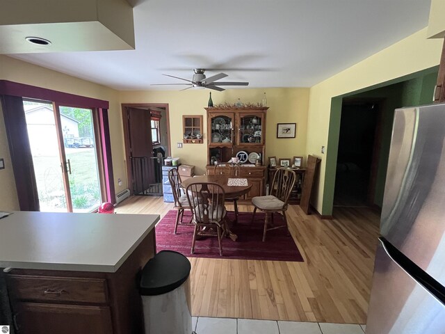 2168 S Lorenz Rd, Tawas City, MI 48763 - dining area featuring a baseboard heating unit, a ceiling fan, and light wood-type flooring