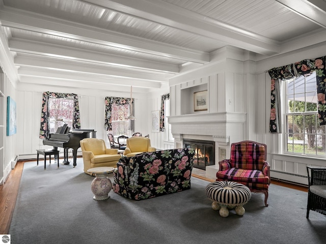 431 Michigan Ave, Charlevoix, MI 49720 - living room with a baseboard heating unit, beam ceiling, a fireplace, wood finished floors, and a decorative wall