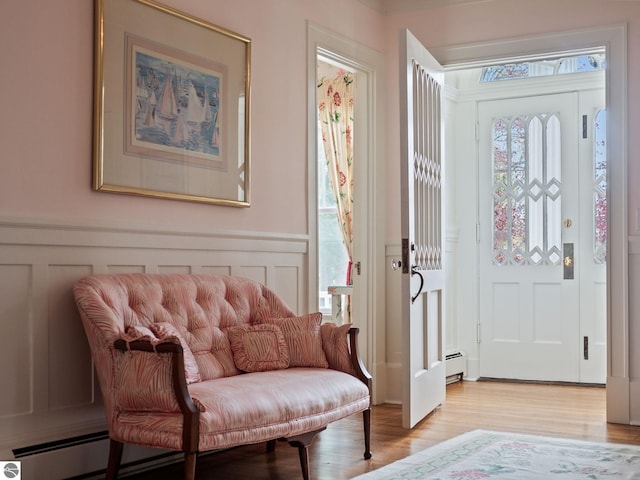 431 Michigan Ave, Charlevoix, MI 49720 - entrance foyer featuring a decorative wall, light wood-style floors, plenty of natural light, a wainscoted wall, and baseboard heating